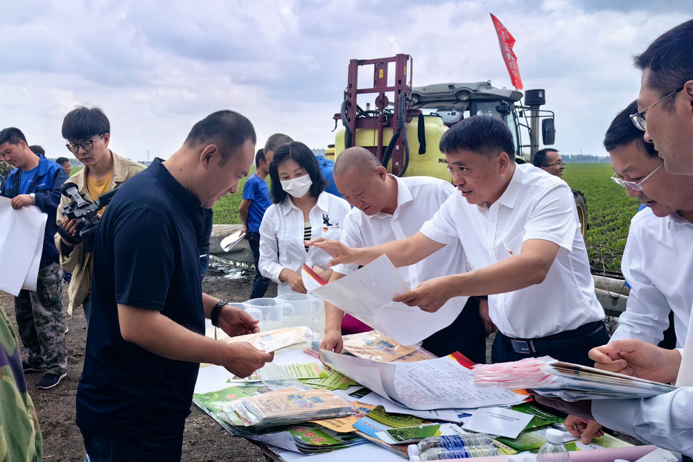 黑龙江省农业农村厅种植业管理处工作人员在哈尔滨市双城区地头，向农民发放科学用农药资料（2023年6月11日摄）。学习贯彻习近平新时代中国特色社会主义思想主题教育工作会议召开以来，黑龙江省农业农村厅种植业管理处将理论学习与实际工作相结合，深入“田间地头”调查研究、深入推进“千万吨粮食增产计划”，助力黑龙江省当好维护国家粮食安全“压舱石”，将主题教育成果融入到维护国家粮食安全的具体实践中。